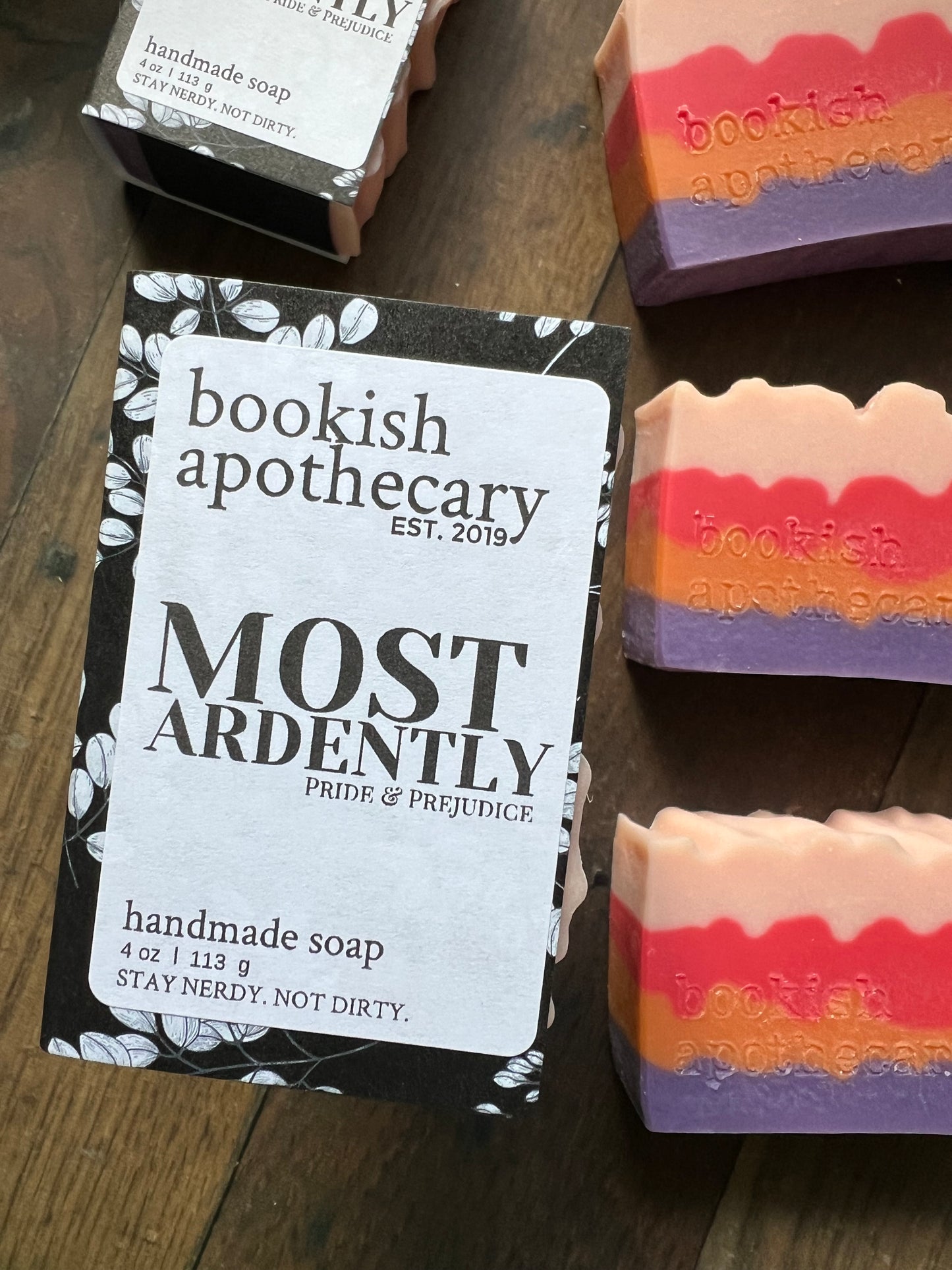 Three bars of soap wrapped to look like books with bookish apothecary branding.