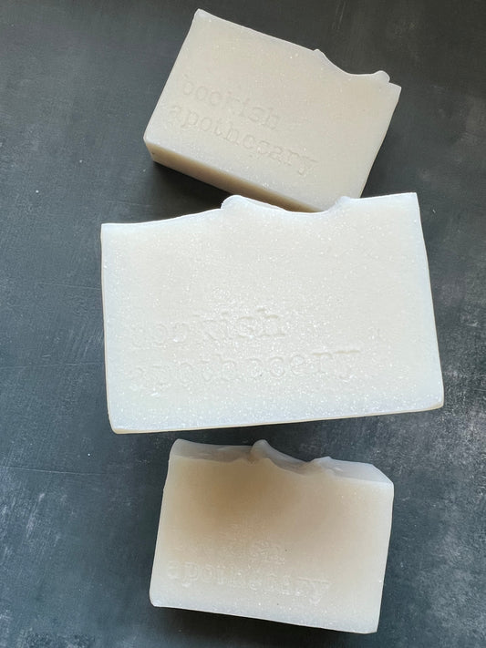 Three pieces of textured white soap on a dark gray surface