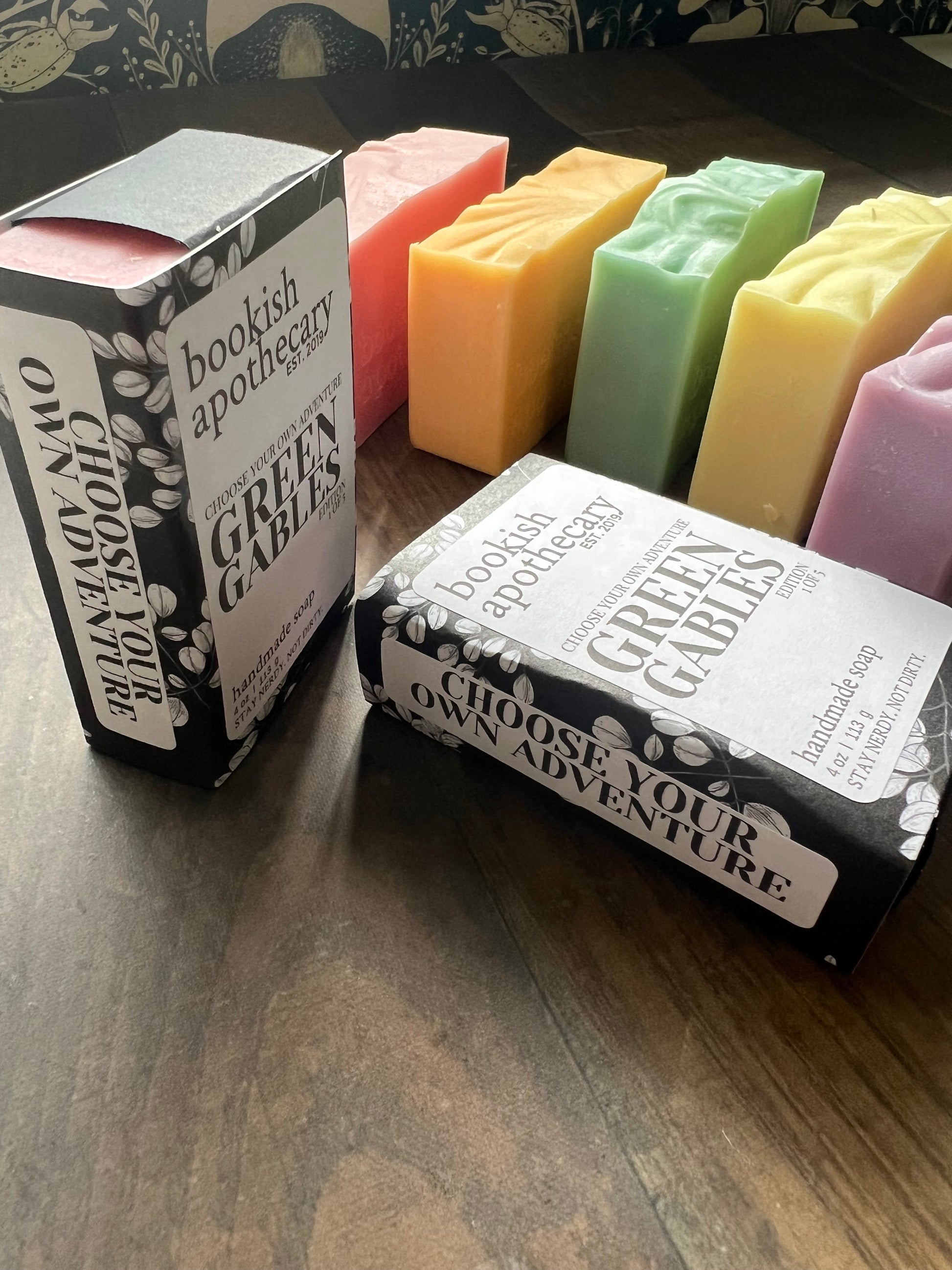 Colorful soap bars with 'Green Gables' packaging on a wooden surface