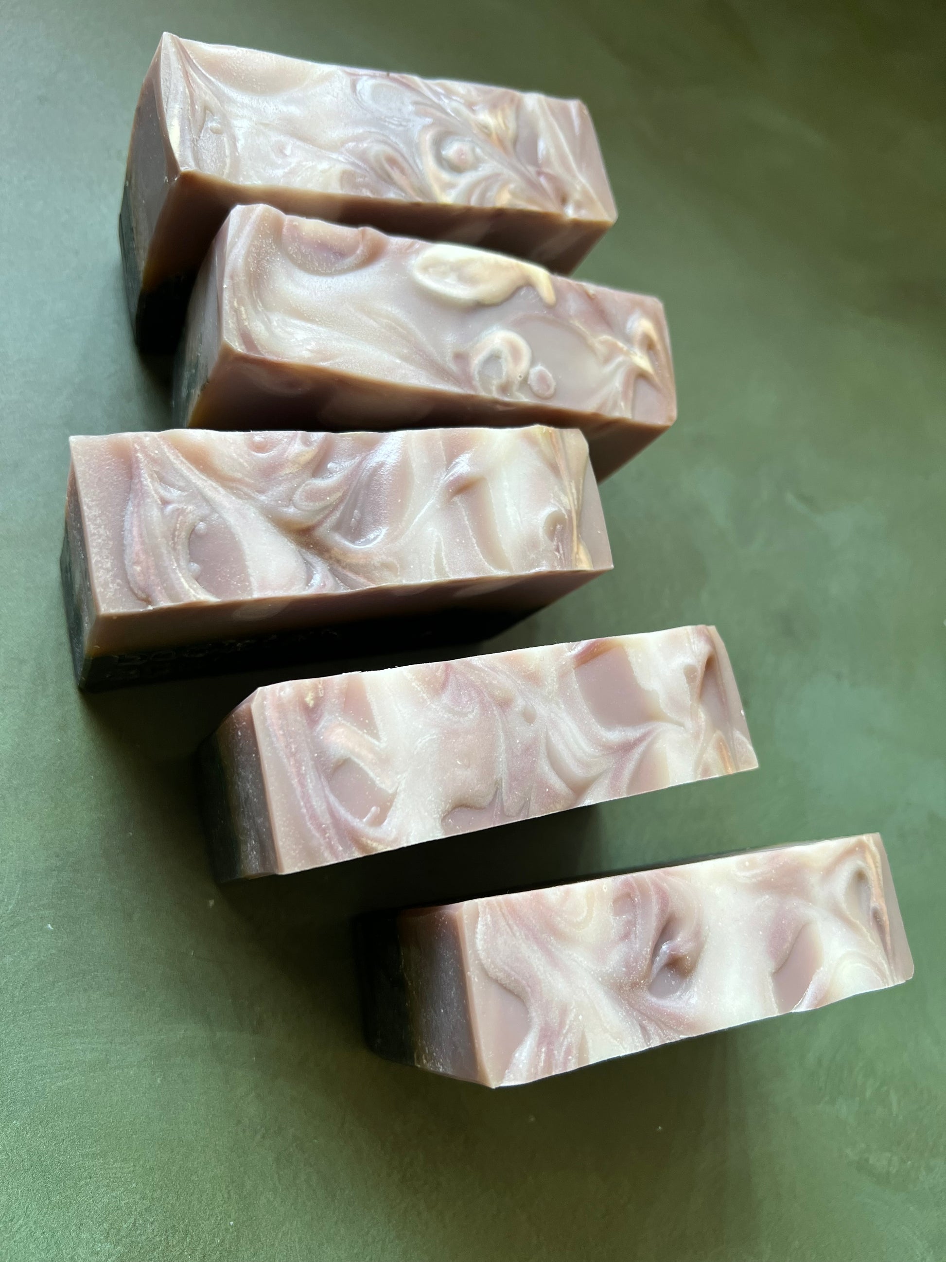 five bars of  soap with a tan top and black bottom stamped with bookish apothecary branding.