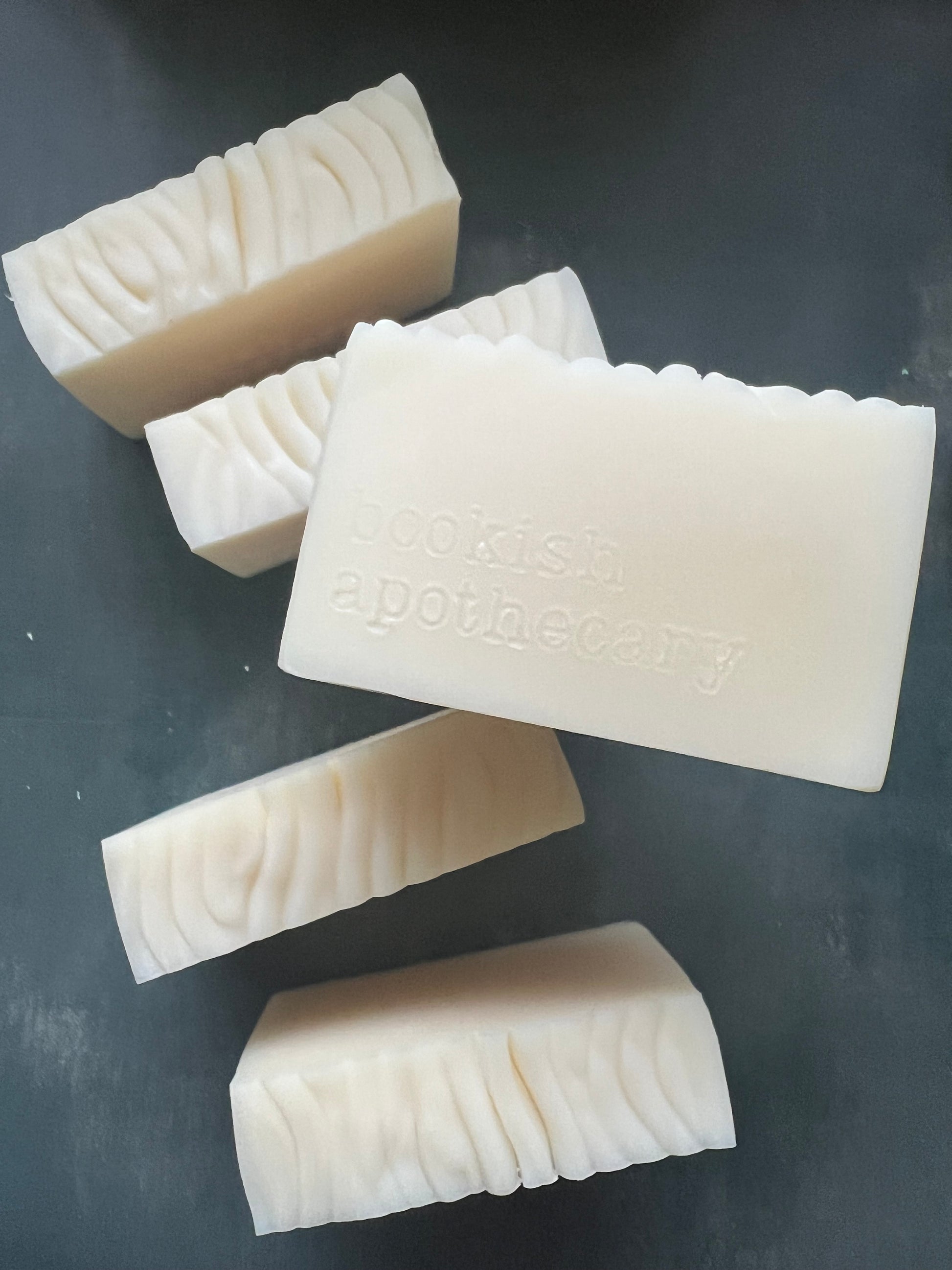 White soap bars with a brand name on a dark surface