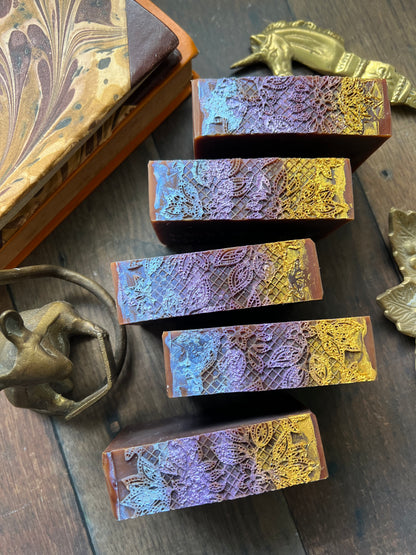 Set of decorative handmade soaps with textured surfaces on a wooden surface.