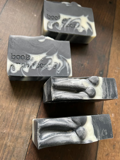 Five bars of soap with a marbled design on a wooden surface
