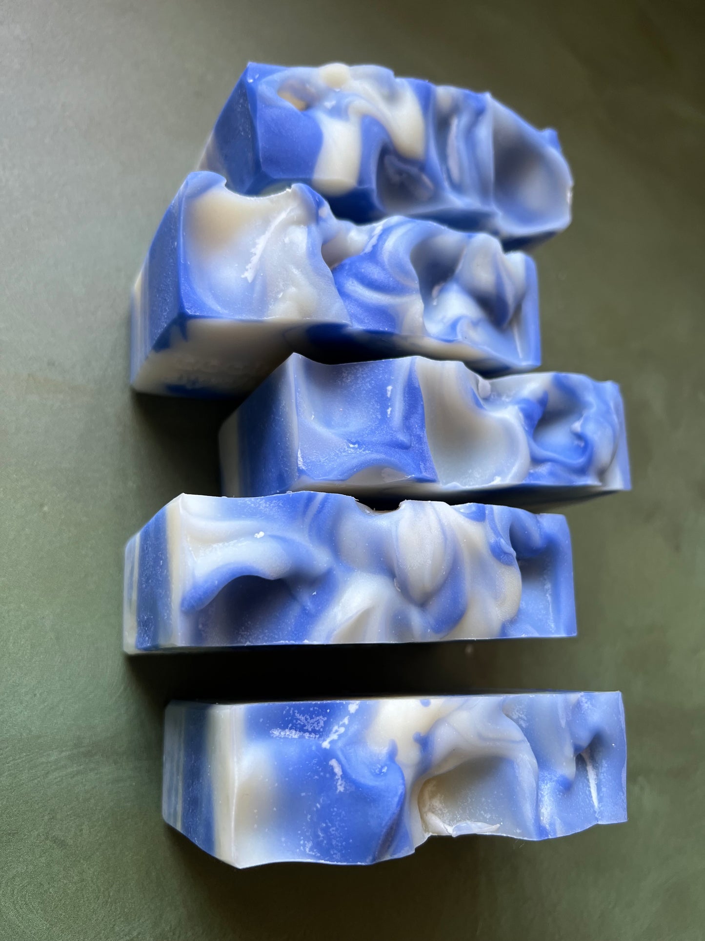five bars of blue and white swirled soaps stamped with bookish apothecary branding.