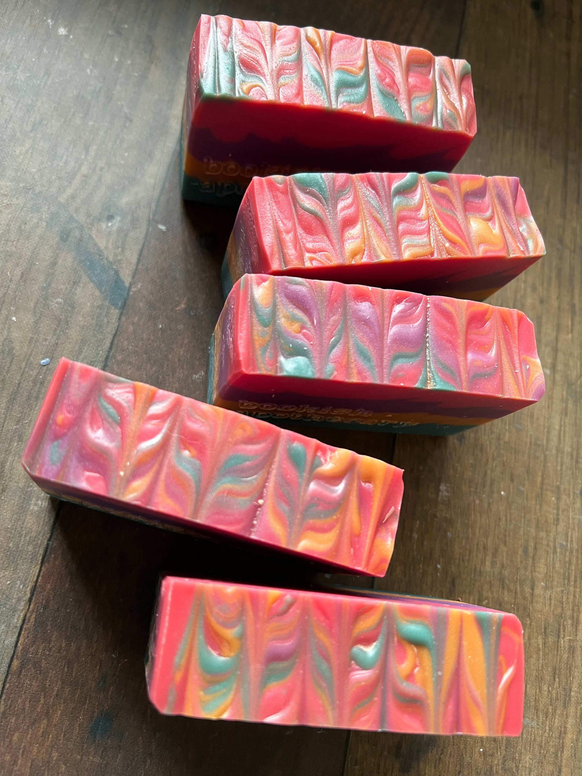 Colorful swirled soap bars on a wooden surface