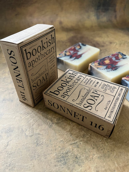 A boxed soap product labeled 'Bookish Apothecary SOAP' and 'SONNET 116' shown with two matching paperboard boxes and one visible soap bar in the background, arranged on a textured beige surface.