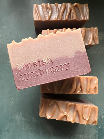 Bar of soap with 'bookish apothecary' branding on a dark surface