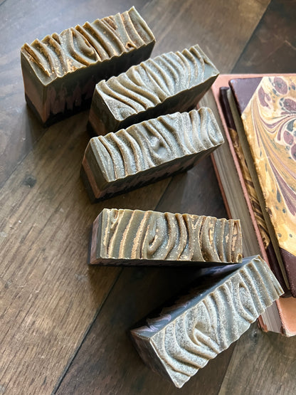five bars of soap with textured tops on a wooden surface