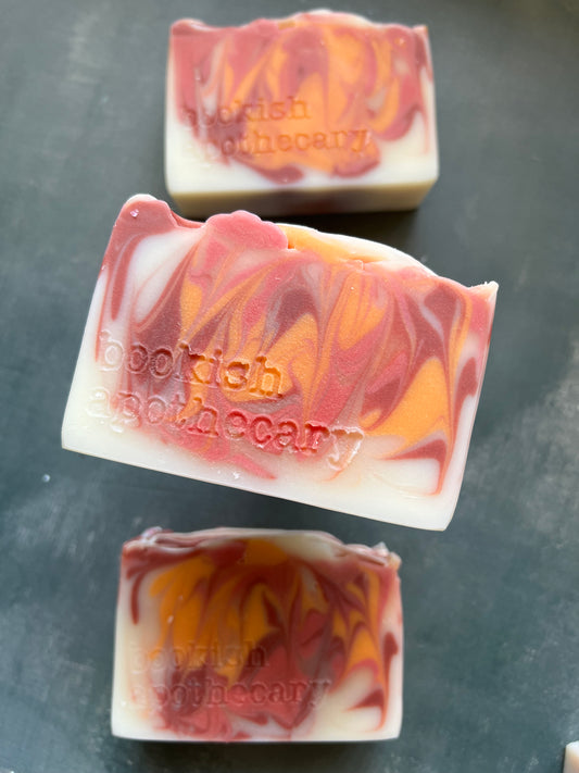 Three bars of soap with marbled design on a dark surface