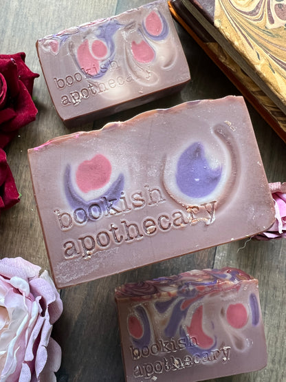 Three soap bars with 'bookish apothecary' branding on a wooden surface.