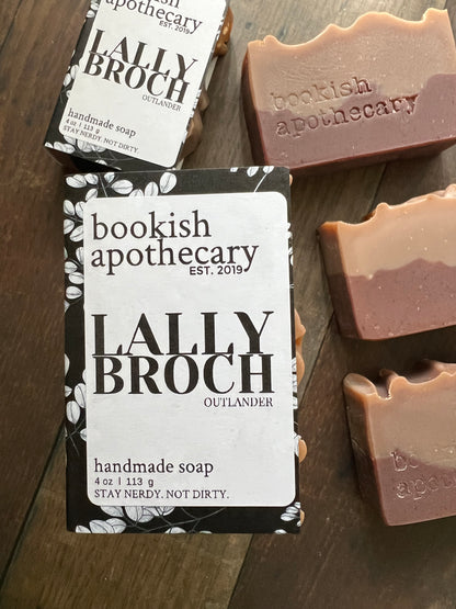 Three bars of soap with 'bookish apothecary' branding on a dark surface