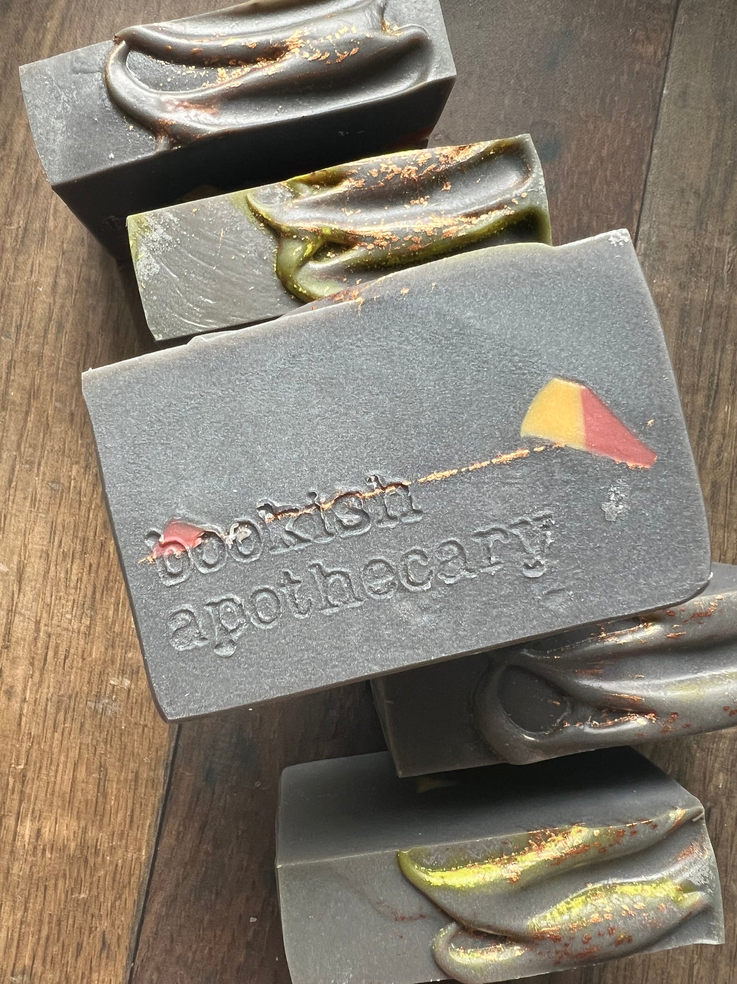 Bar of soap with 'bookish apothecary' branding on a wooden surface