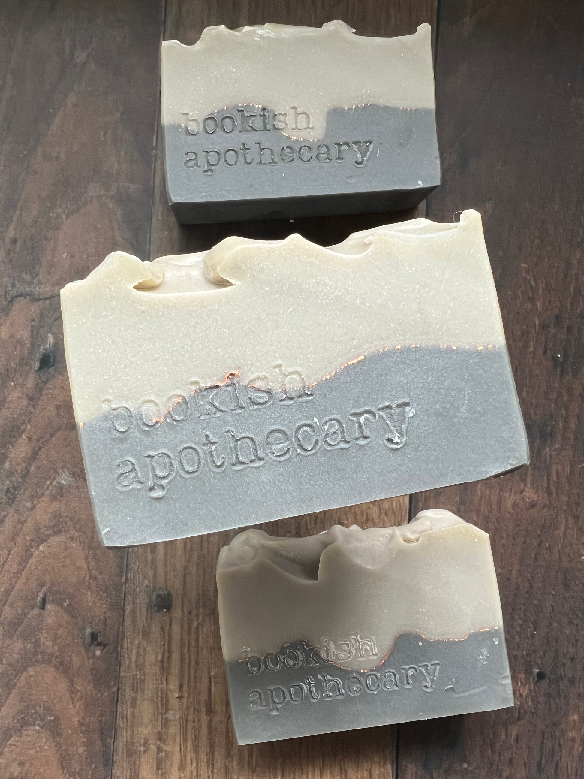 Three bars of soap from 'bookish apothecary' on a wooden surface
