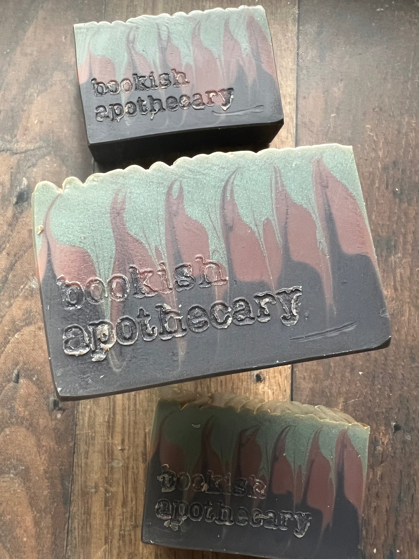 Three bars of soap from 'bookish apothecary' on a wooden surface