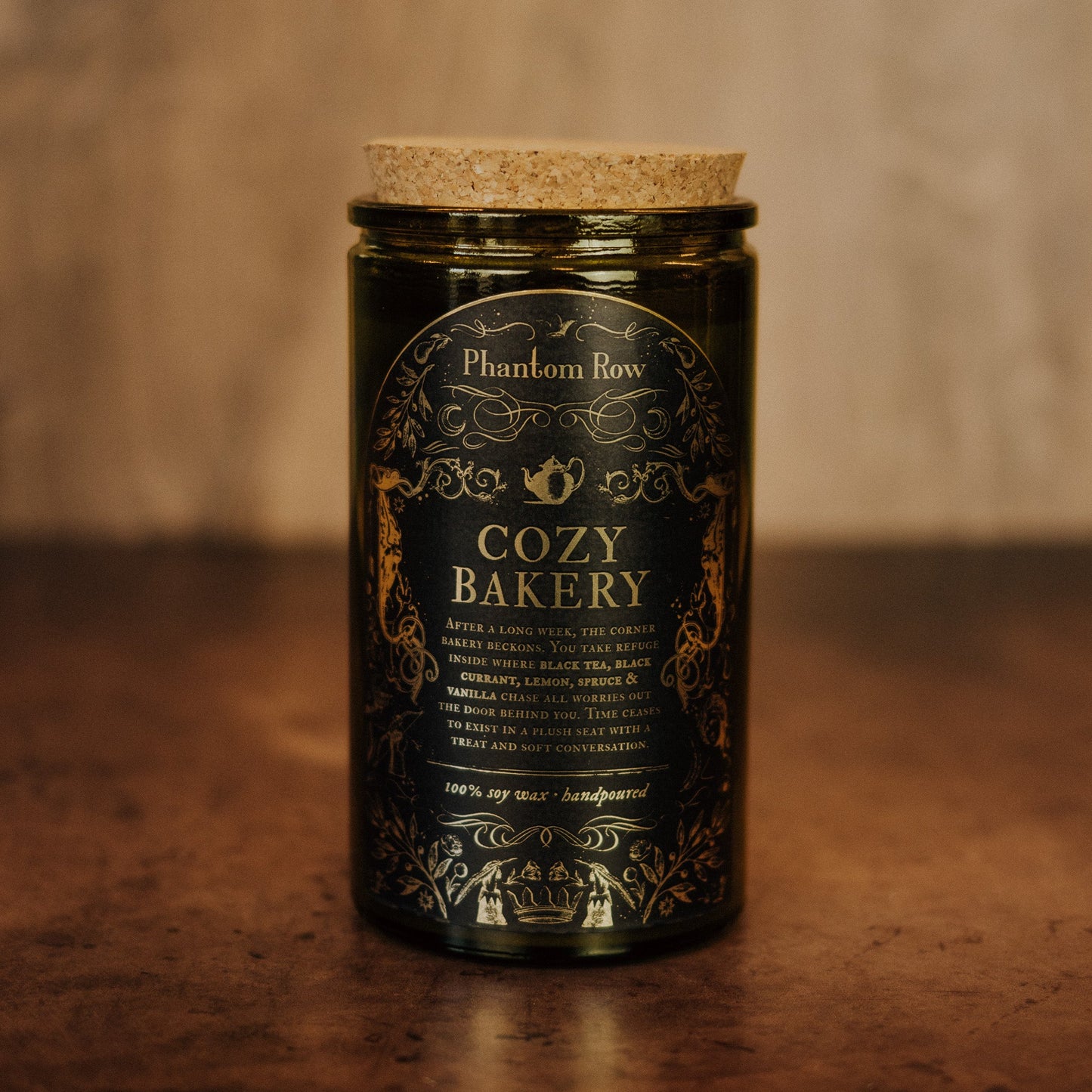 Candle jar with 'Cozy Bakery' label on a wooden surface