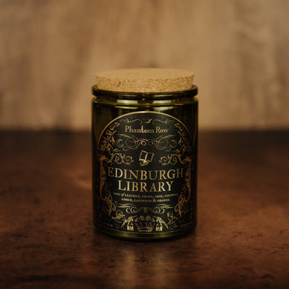 Jar of Edinburgh Library candle with decorative label on a wooden surface