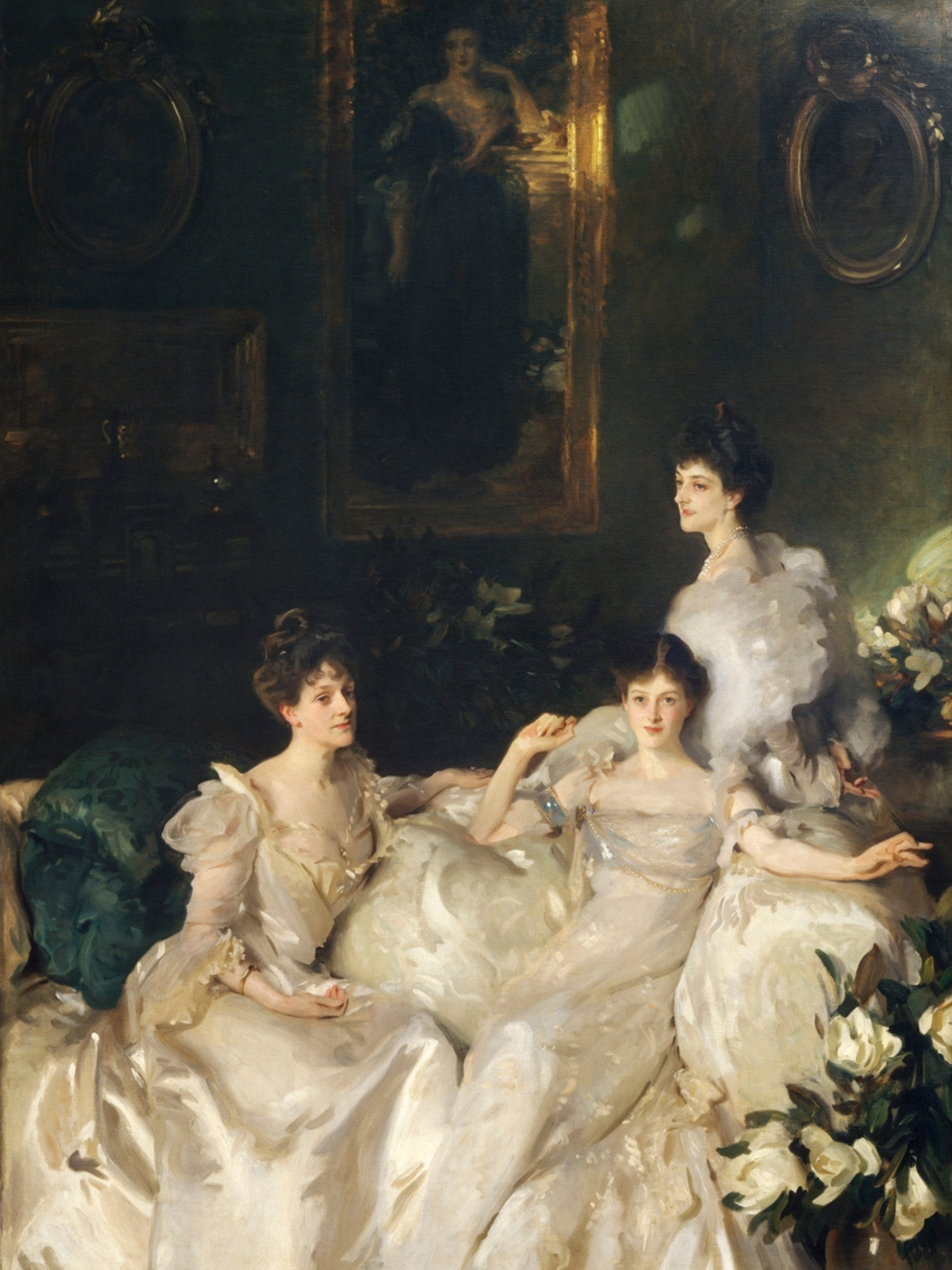Three women in formal attire sitting together with decorative elements in the background