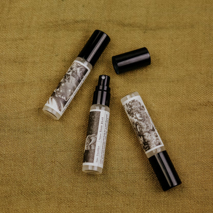 Three room mist spray bottles with black and white labels on a textured brown surface